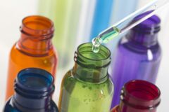 Eine Pipette träufelt Flüssigkeit mit Mikronährstoffen in eine Flasche